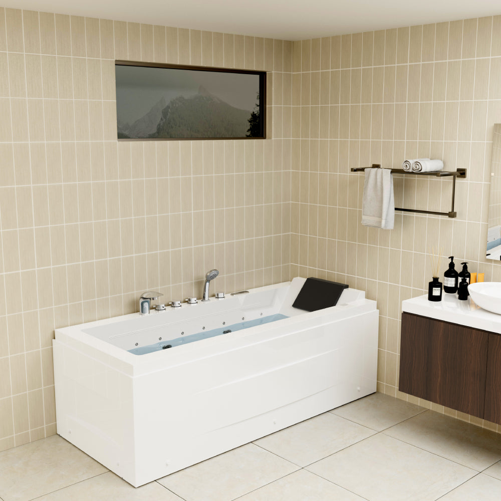 A bathroom with beige tiled walls features a large rectangular white bathtub equipped with a black headrest and silver faucets. Above the tub is a window with a mountain view. A towel rack and a dark wood vanity are nearby.