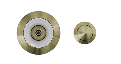 Two round metallic objects with a brushed brass finish. The left object is larger with a circular white rim and central point, resembling the Custom Nozzle Color for recessed ceiling lights or sprinkler heads. The right object is smaller, featuring a simple, smooth surface.