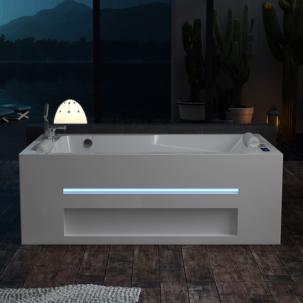 In a dimly lit room, the Empava 71 in. Alcove Massage Thermostatic 2-Person LED Tub With Right Drain showcases its modern, rectangular design with a sleek white finish. The tub features a glowing horizontal light strip on the side and includes an inline heater for optimal relaxation. Nearby potted cacti add a natural touch, while a large window reveals a breathtaking mountainous landscape outside.