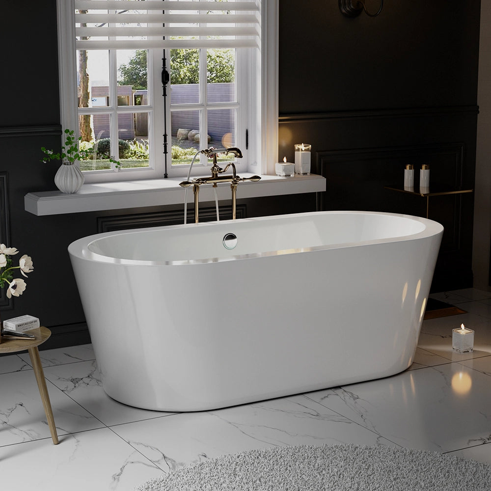 A modern bathroom features a white 59" Freestanding Soaking Tub with Center Drain, showcasing an elegant oval design, placed against a black paneled wall. The floor is adorned with white marble featuring grey veins, and a nearby round grey rug complements the space. Natural light streams in through a window with white blinds, illuminating candles and a small table decorated with flowers.