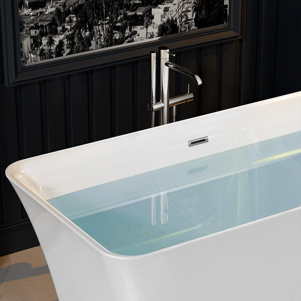 Close-up of the 59" Freestanding Soaking Tub with Center Drain, a modern white acrylic bathtub partially filled with water in a contemporary bathroom. The background features a dark wall and a monochromatic cityscape picture. A sleek, chrome-finished faucet is positioned beside the tub.