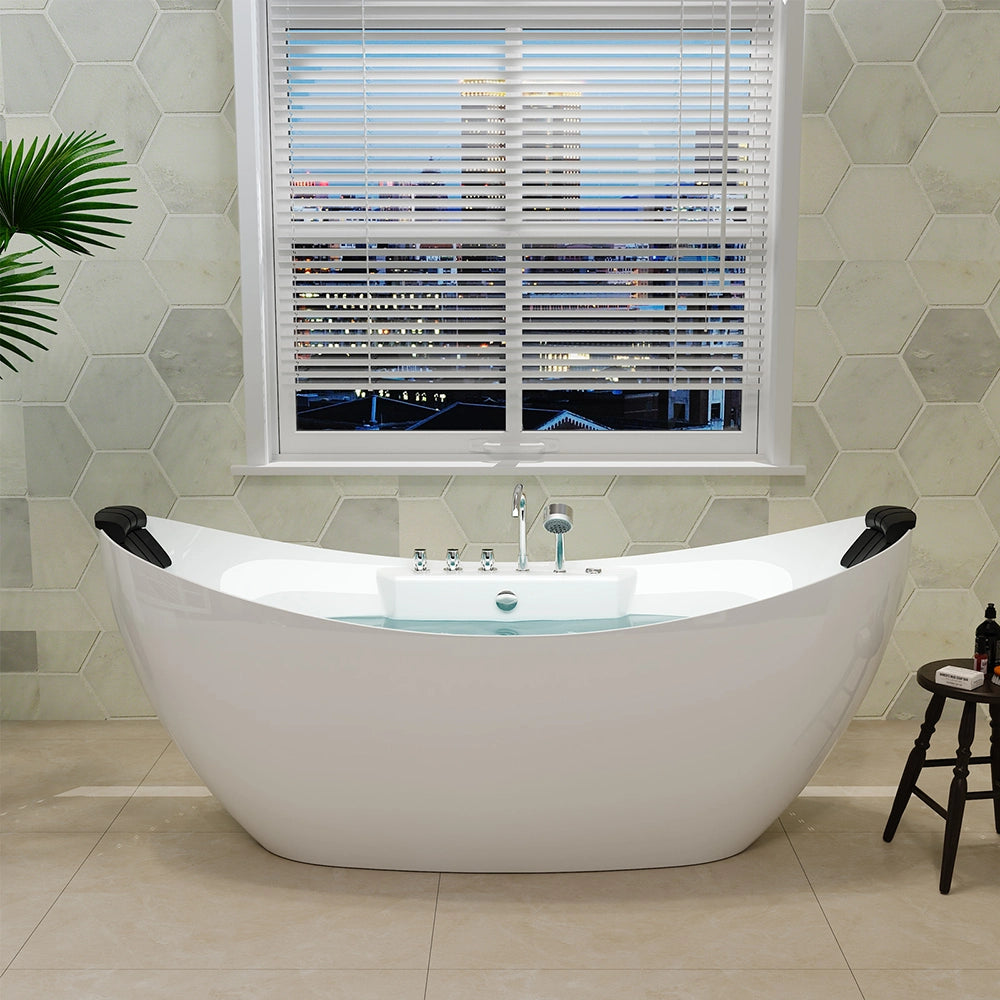 A modern bathroom features the 67" Freestanding Boat-shaped Whirlpool Bathtub with Center Drain, a white tub with headrests, positioned near a window with horizontal blinds. The view outside shows a cityscape at dusk. Made from crack and mold-resistant acrylic material, there's a green plant to the left and a small wooden stool on the right side of the tub.