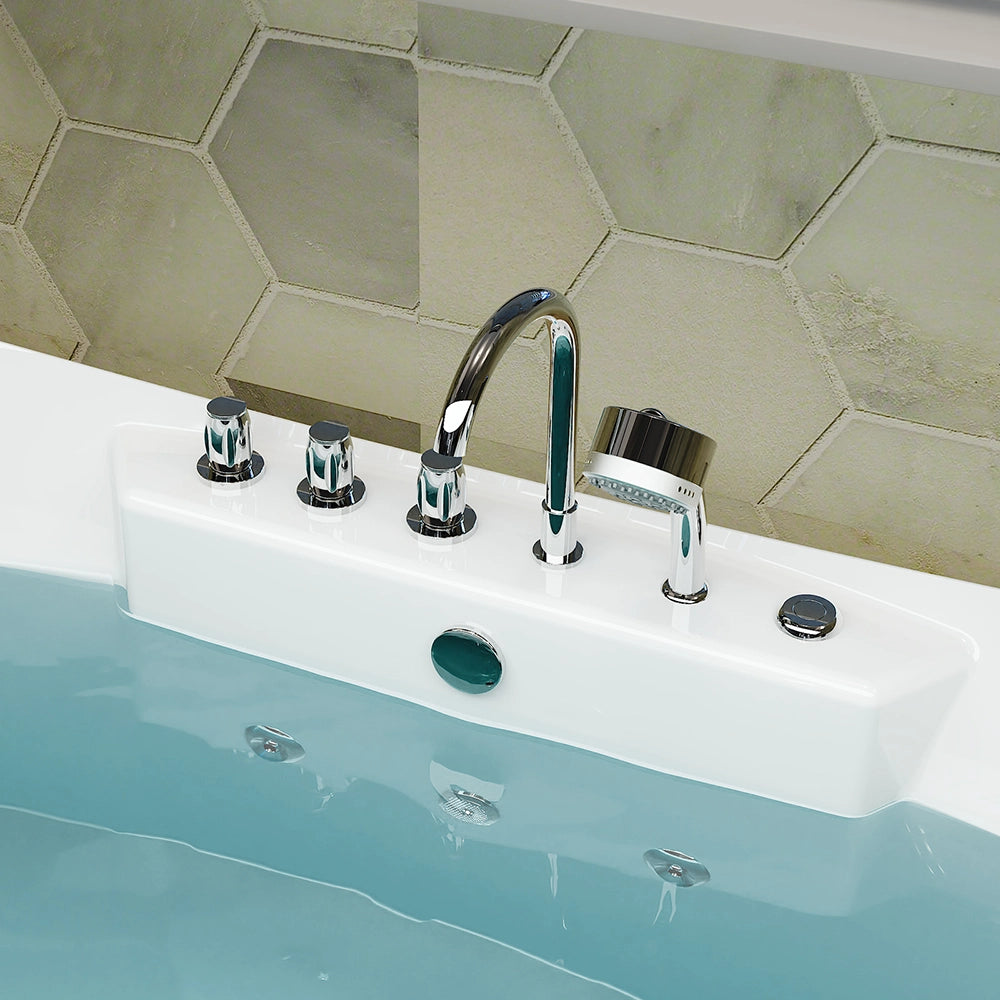 Close-up of a bathtub faucet setup with modern, chrome fixtures. The set includes a central faucet, a handheld shower head, and various control knobs against a backdrop of hexagonal, textured wall tiles. The 67" Freestanding Boat-shaped Whirlpool Bathtub with Center Drain is filled with water and crafted from durable acrylic material.