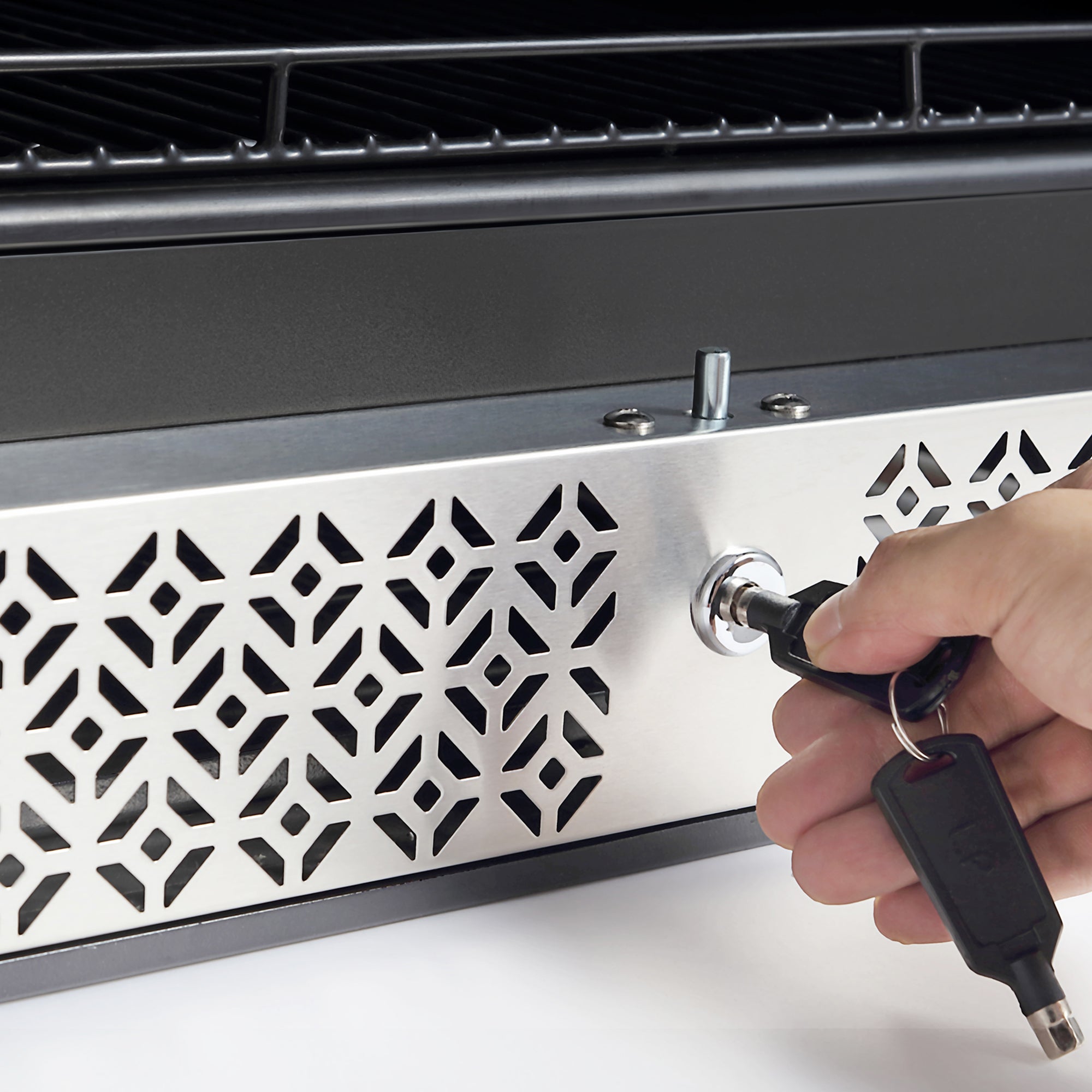 A hand is inserting a key into a lock on a metal panel with a decorative geometric pattern, with the edge of an Empava 24 Inch Freestanding & Under Counter Beverage Fridge visible at the top of the image.