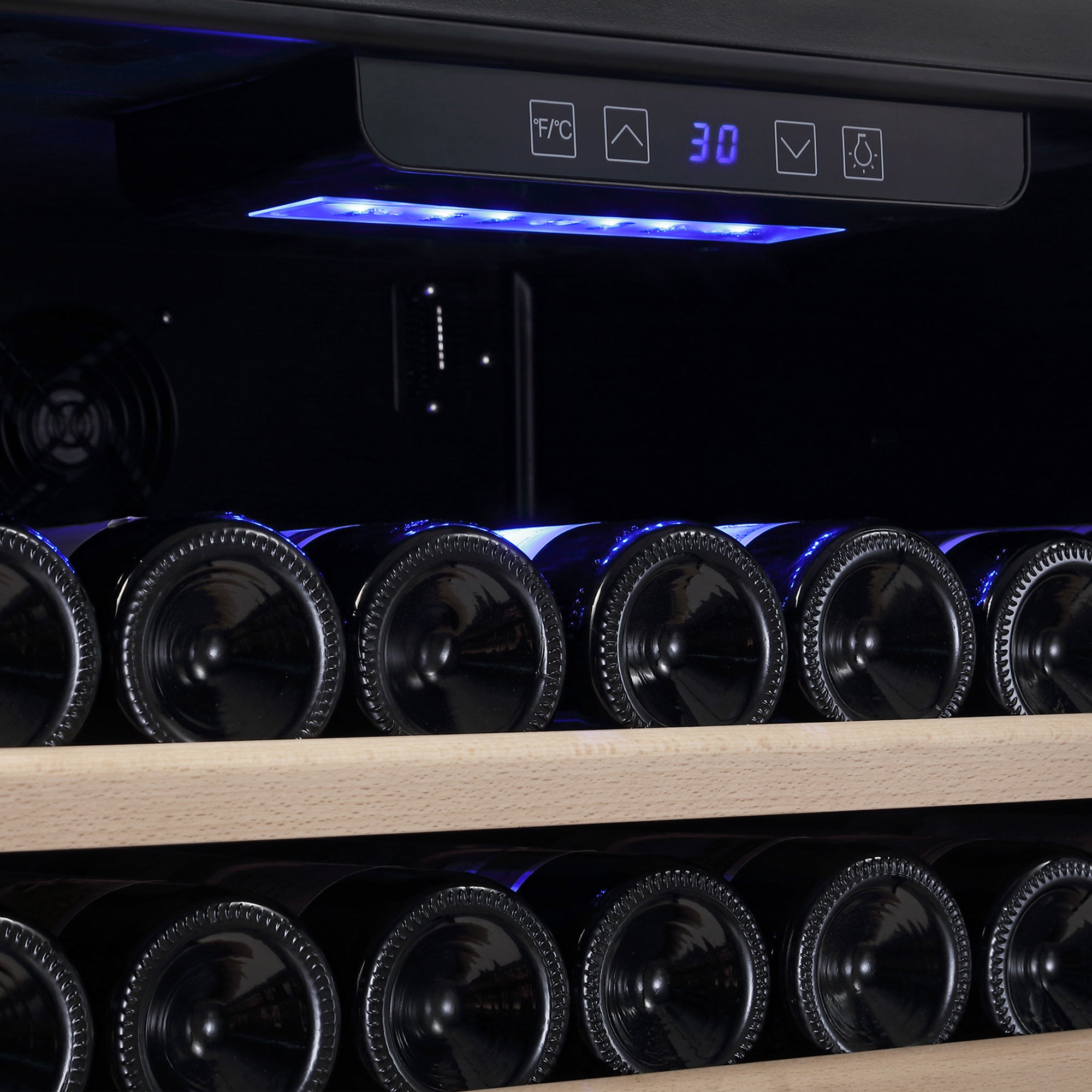 Close-up image of rows of wine bottles stored horizontally on wooden shelves inside an Empava 24 Inch Wine Cooler Wine Fridge 52 Bottles. The fridge features a digital temperature display set to 30°F, and blue LED lights illuminate the interior.