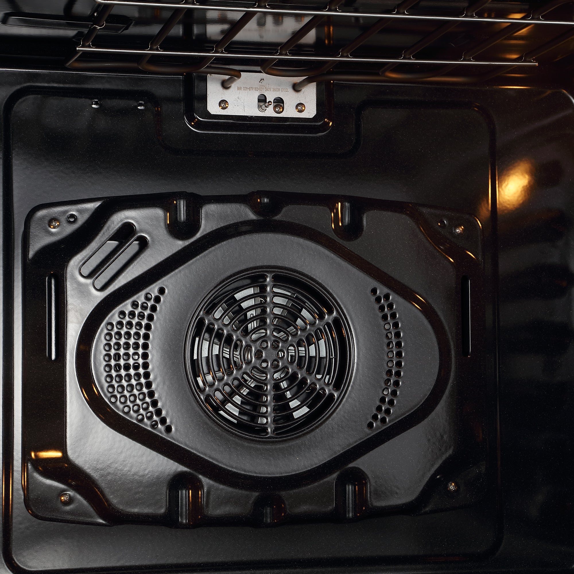 Close-up view of the interior of the Empava 30" Electric Double Wall Oven, highlighting the fan and heating element positioned at the back. The fan is encased in a perforated metal cover, ideal for air frying. The interior looks clean and well-maintained, with oven racks seen at the top.