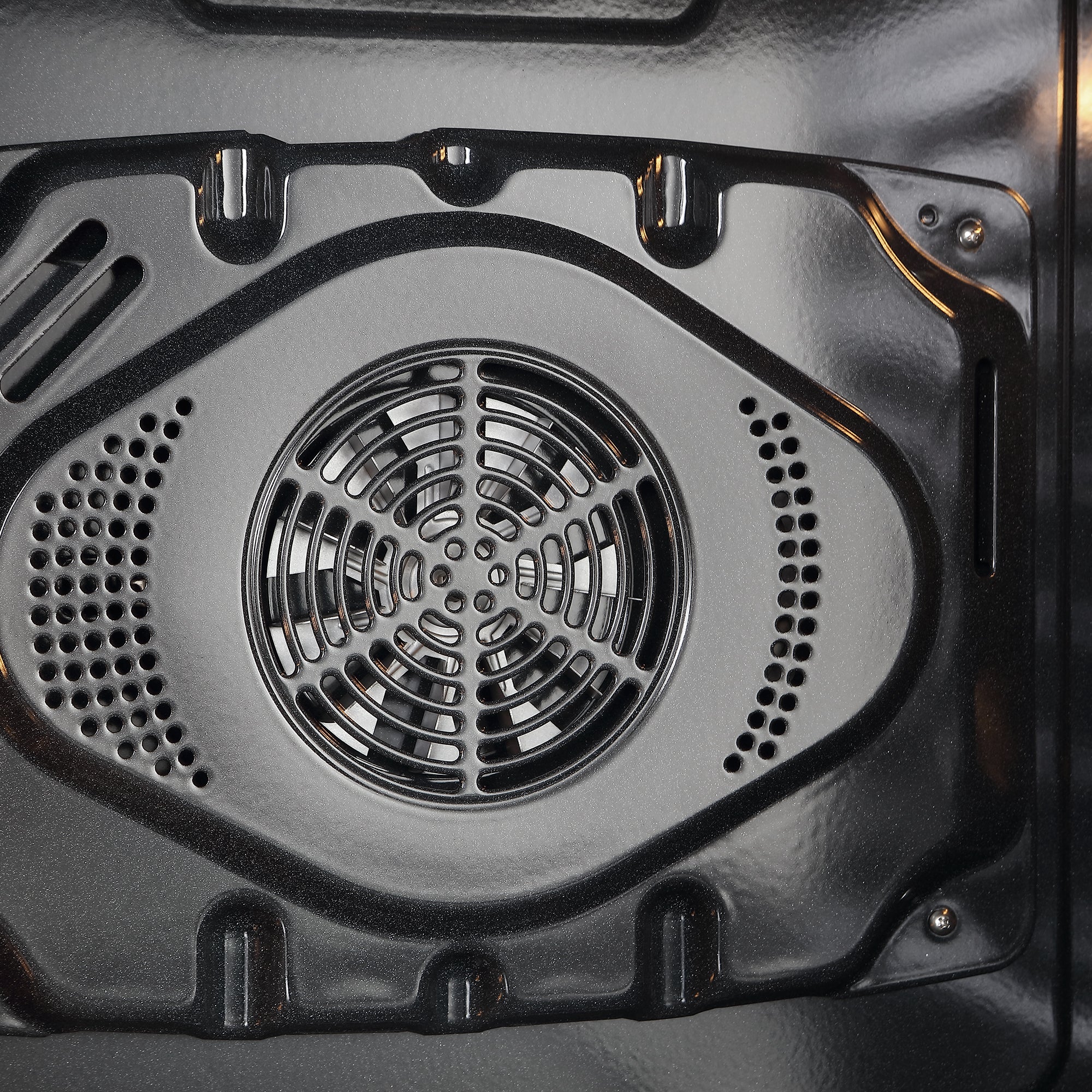 Close-up view of the interior of an Empava 30" Electric Single Wall Oven. The image focuses on the back panel, which features a circular vent with multiple concentric rings and perforations. The metallic surface of the oven appears clean and polished, showcasing its steam self-clean function for effortless maintenance.