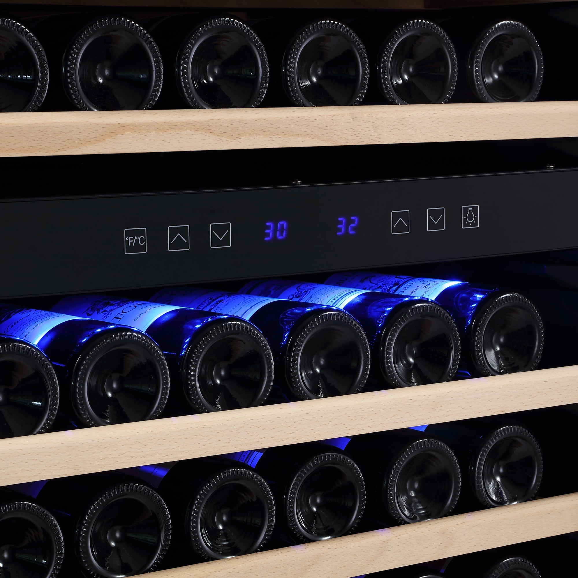 The Empava 55" Tall Dual Zone 100 Bottle Wine Fridge, equipped with wooden shelves, holds multiple bottles and features a digital control panel that displays dual temperature zones of 30 and 32 degrees to protect your collection from wine oxidization. The bottles are elegantly illuminated with blue backlighting.