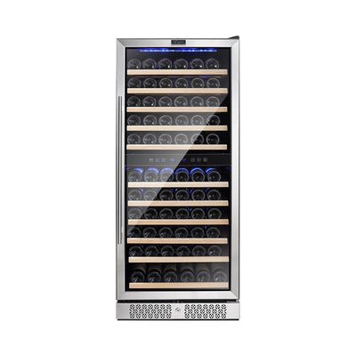 The Empava 55" Tall Dual Zone 100 Bottle Wine Fridge features a sleek stainless steel design with a glass door, showcasing multiple shelves filled with wine bottles. It offers dual temperature zones controlled by a digital display near the top and blue LED lighting inside to illuminate the bottles. The lower front part includes a ventilation grid to prevent wine oxidation.