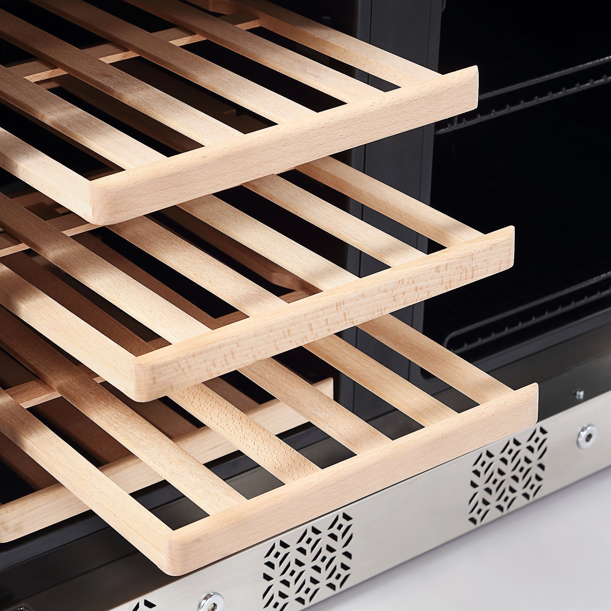 Close-up of a set of three wooden shelves inside the Empava Dual Zone Wine & Beverage Cooler Fridge. The slatted design of the shelves allows for ventilation. The background highlights the interior of the cooler, featuring its sleek, metallic structure and ventilation grilles at the bottom.