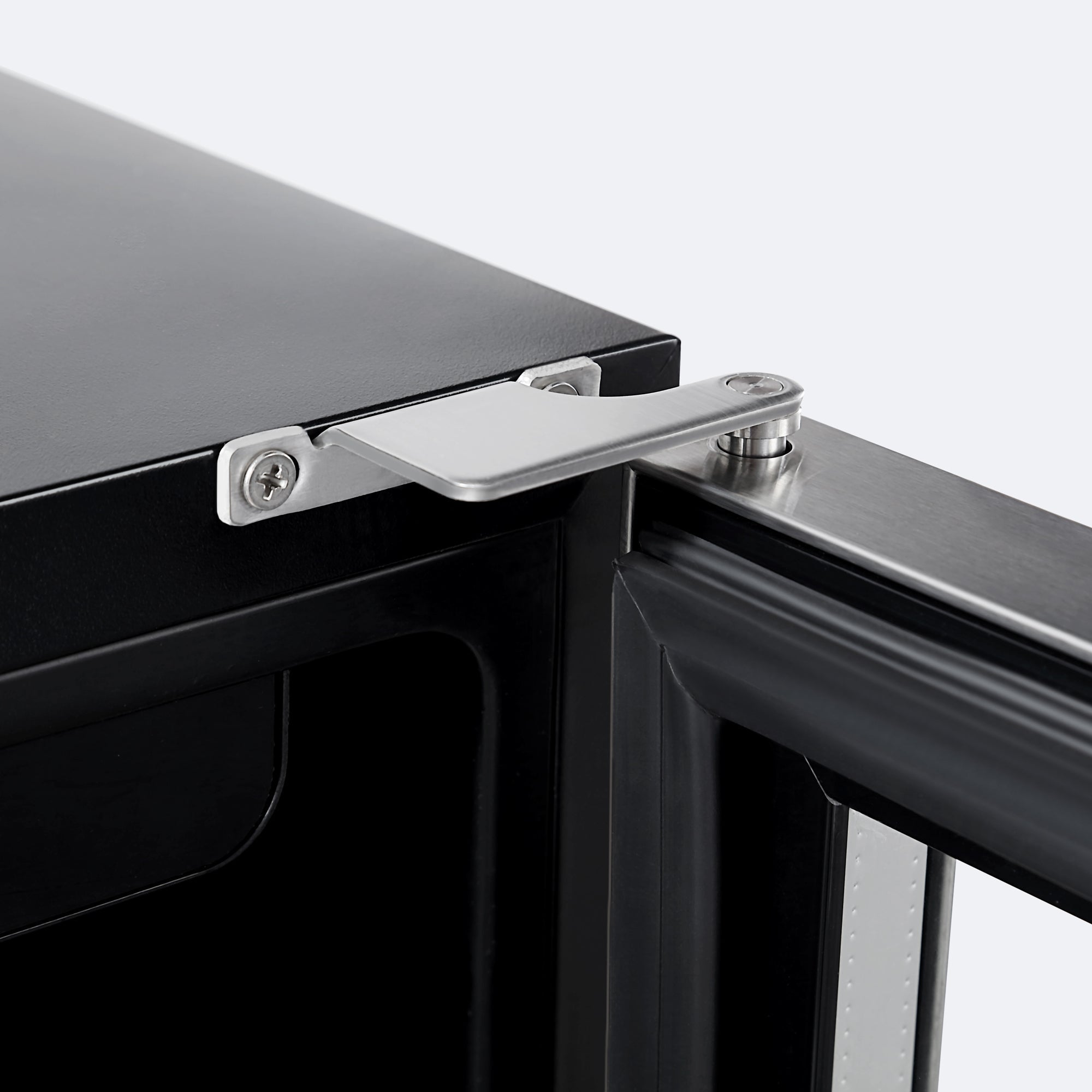 Close-up image of a metal hinge connecting a black door to the frame of an Empava Dual Zone Wine & Beverage Cooler Fridge. The silver hinge, made from reinforced material, is secure and well-aligned, indicating sturdy construction. The door is slightly open, revealing a glimpse of the interior's dual zones.