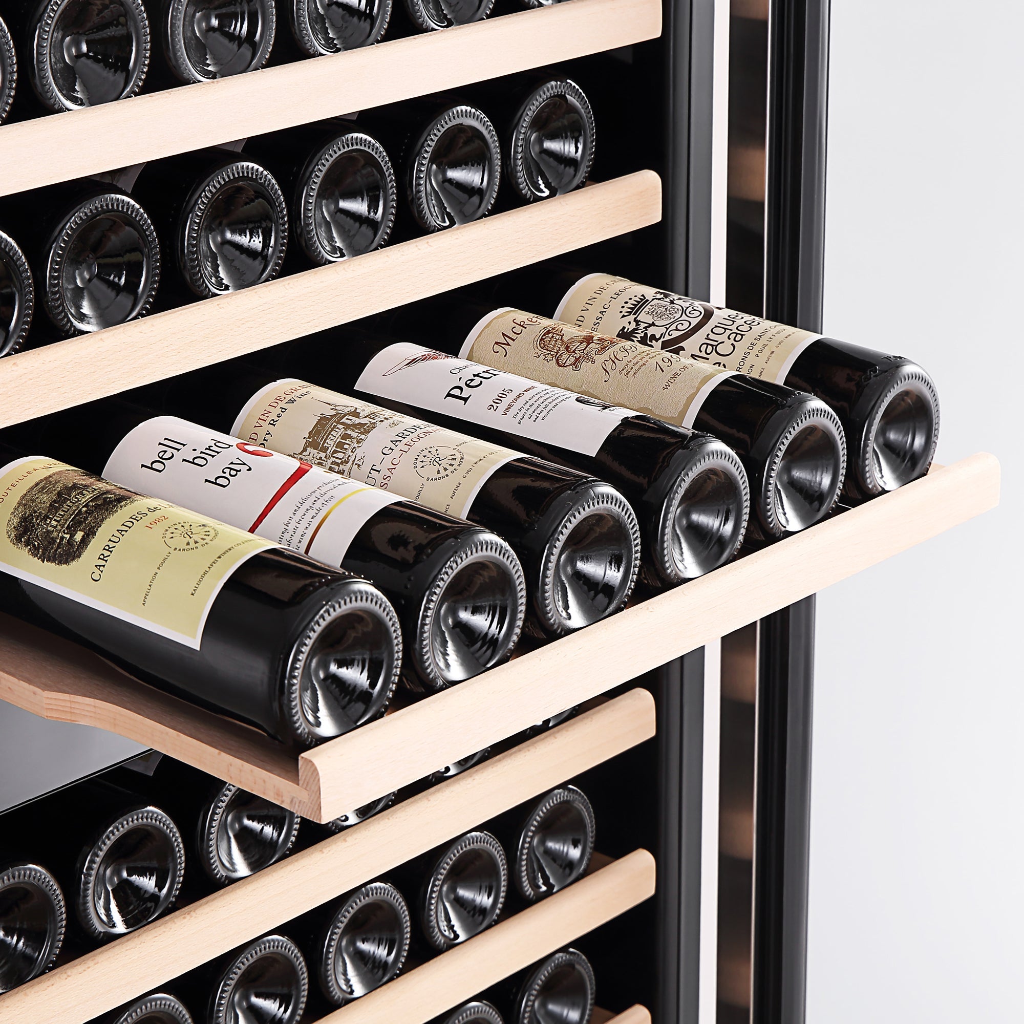 A close-up of the Empava Dual Zone Wine Cooler 70" Tall Wine Fridge reveals a slide-out wooden shelf showcasing several bottles of red wine lying horizontally. The labels on the bottles are partially visible. This elegant wine cooler boasts an enormous capacity and features additional shelves along with dual zones for optimal temperature distribution for all your wines.