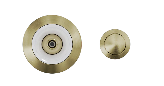 Two Custom Nozzle Color drains with different sizes are shown. The larger drain has a central hole with a white ring around it, while the smaller drain features a completely brass surface with a slotted design. The background is plain white.