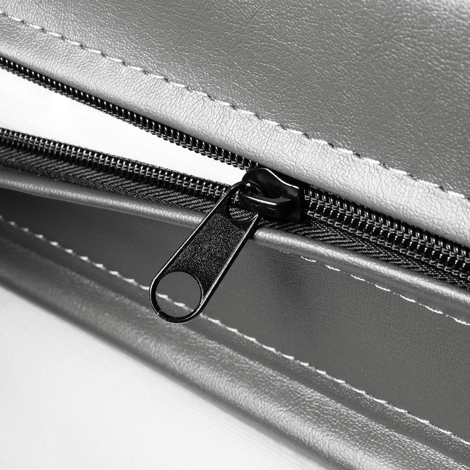 Close-up of a black zipper on the gray leather surface of the Outdoor Hot Tub Cover for Empava SPA3527. The zipper is open, revealing a white background through the opening. The texture of the leather and the stitching details around the zipper are clearly visible.