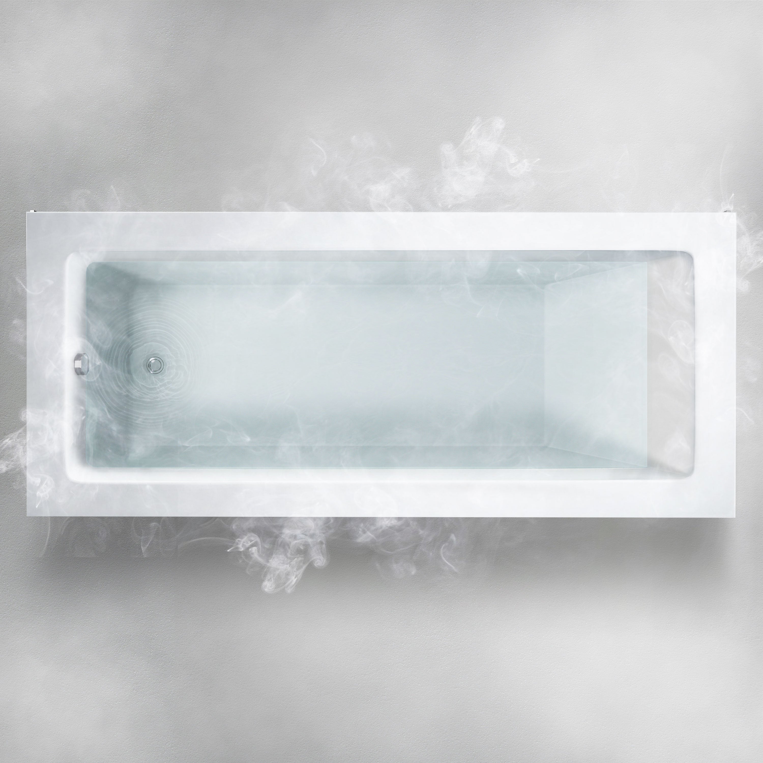 A top-down view of the Custom Function rectangular white bathtub filled with steaming hot water. The steam creates a misty effect around the bathtub, giving off a sense of warmth and relaxation. The glossy, clean surface of the tub contrasts with the surrounding mist.